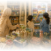 A warm watercolor illustration depicting a mother building systems to reduce daily friction. Prepared fruit, organized groceries, reusable containers, and helping children reflect the unseen accommodations many women create to navigate chronic fatigue, brain fog, and limited cognitive bandwidth.
